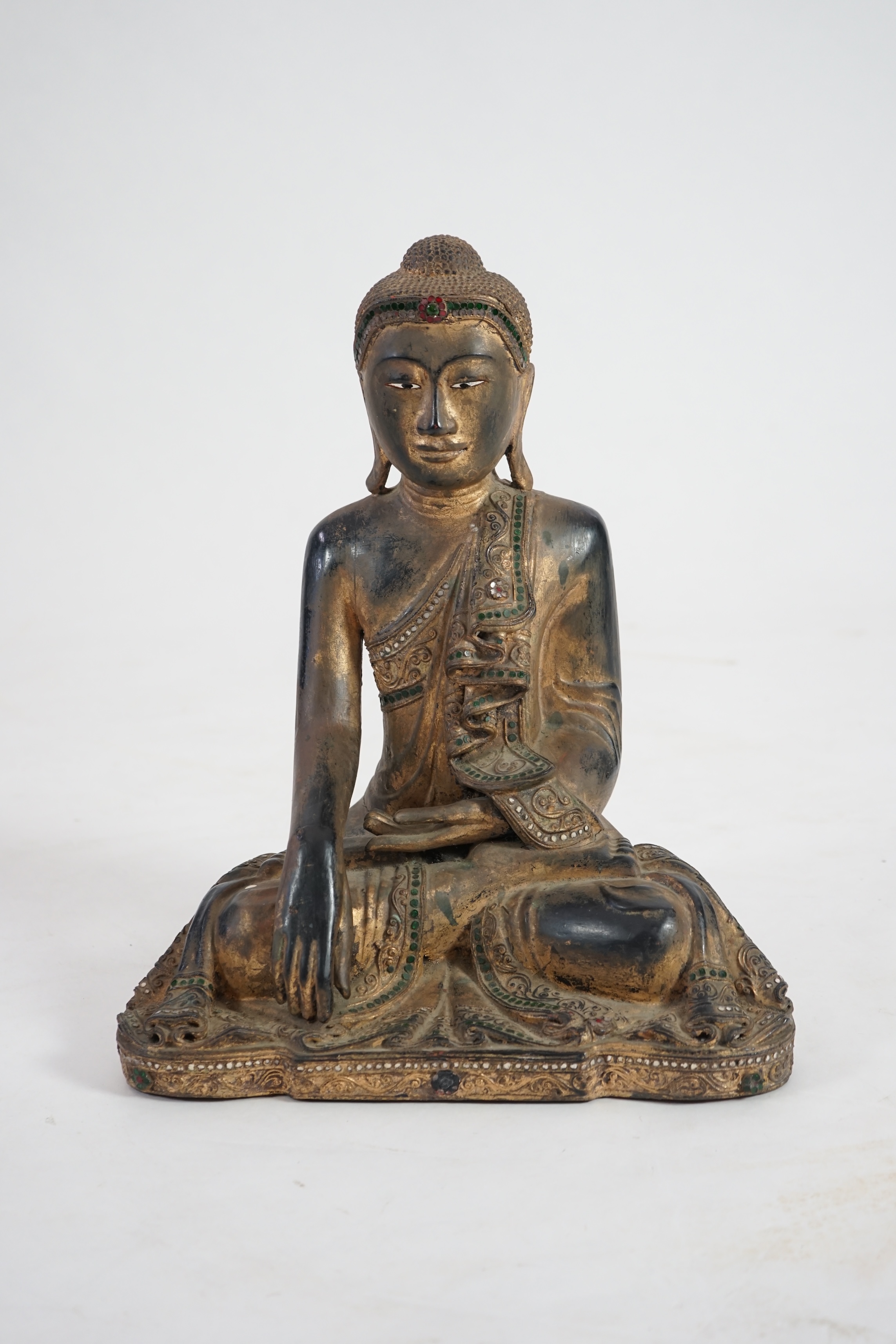 An Asian gem set lacquered and carved wood Buddha